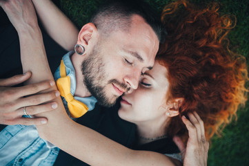 the guy and the red girl closed their eyes and lay on the ground