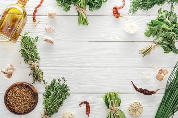 top view of green herbs and spices on white wooden table with copy space