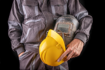 Fototapeta premium A production worker in workwear with a welding mask in hand. Special workwear for employees.