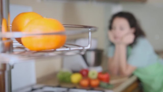 Enjoy the vitamins. Pretty woman with fresh vegetables in the kitchen.
