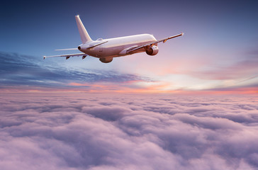 Avion de ligne commercial volant au-dessus de nuages spectaculaires dans une belle lumière du coucher du soleil. Notion de voyage.