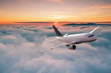 Poster Commercieel vliegtuigstraalvliegtuig dat boven dramatische wolken in prachtig zonsonderganglicht vliegt. Reisconcept. © Lukas Gojda