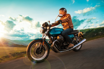 Obraz na płótnie Canvas Motorcycle driver riding in Alpine highway, Nockalmstrasse, Austria, central Europe.