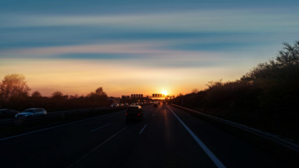 Sunset road . Cars and trucks at sunrise . Night highway . 