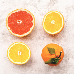 four citrus elements on white marble background top view flat lay