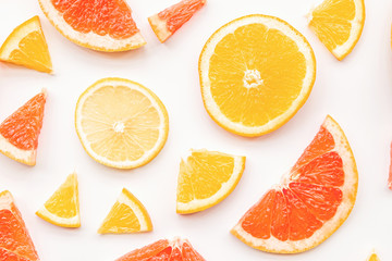 Fresh summer citrus grapefruit, orange and lemon slices pattern on white background flat lay top...