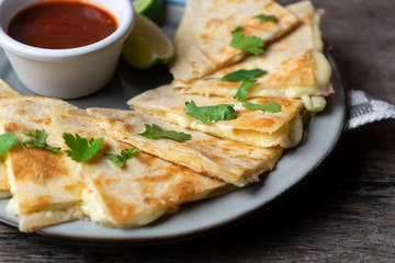 Mexican quesadillas cutted in triangle with flour tortillas and red sauce