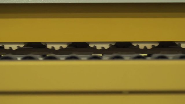 Close-up of moving mechanisms of yellow milling machine in a working room of factory or industrial plant. Action. Woodworking industry