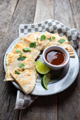 Mexican quesadillas cutted in triangle with flour tortillas and red sauce