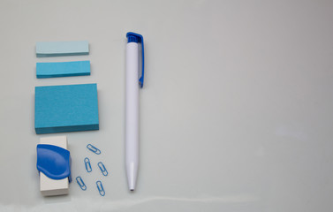 Materials on white table, pen, message blocks, paper clips, rubber and page markers