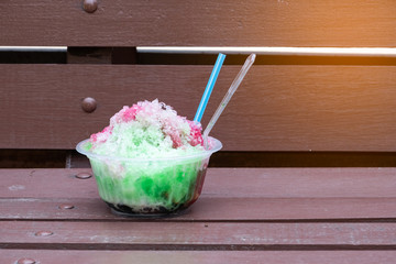 Combine all the clear ice in a cup of nectar that has many colors placed on the wood.