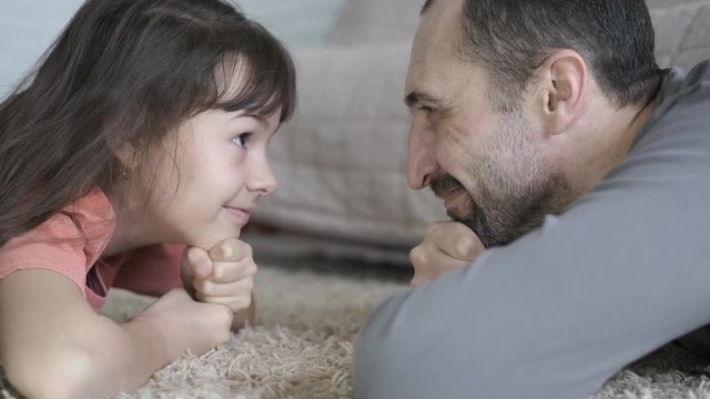 Father and daughter look into each other's eyes. Portrait of a father and daughter.