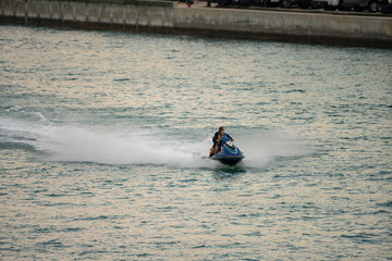 Young couple riding a fast waverunner in Miami
