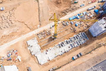 building of new city apartment complex. yellow tower crane standing at construction site. drone photography.
