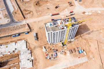 building of new residential complex. yellow tower crane near block building in progress. aerial top view