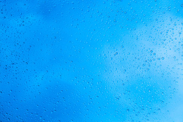 Drops of rain on blue glass background