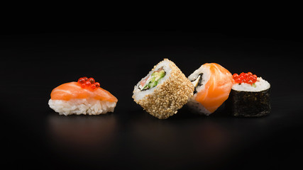 Sushi with red caviar on a black table. Macro