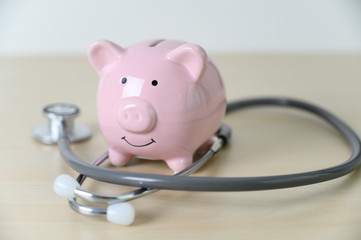Piggy bank with stethoscope  financial checkup or saving for medical insurance costs