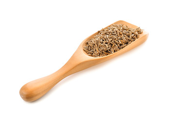 caraway seeds in wood scoop on white background