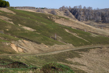 the road which is going down on a green slope, Siberia