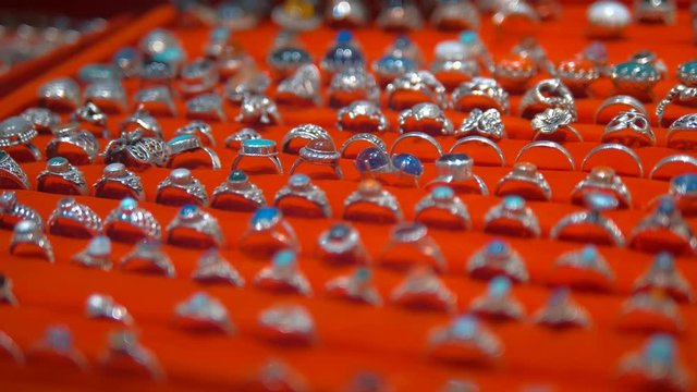 Silver rings with semi precious stones in traditional Indian style are sold as souvenirs for a long memory of India. Shot in motion