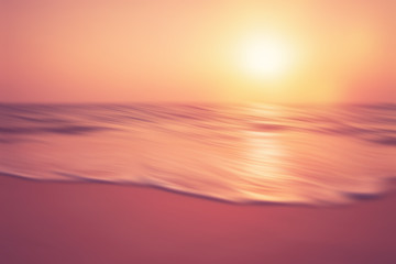 Motion blur tropical sunset beach with bokeh sun light wave abstract background.