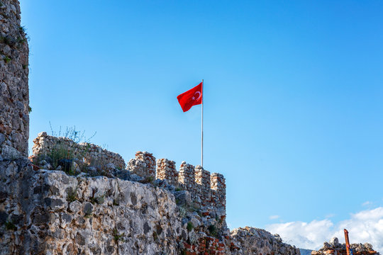 The fortress wall with the Turkish flag against the blue sky
