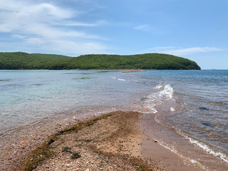 Coast of the island of Shkot from the side of Russkiy (Russian, Russky) island in spring sunny day. Vladivostok, Russia
