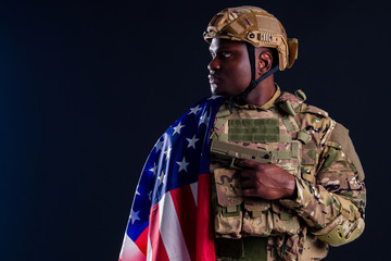 military army african male warrior camouflage suit sorrow sadness wrapped in an American flag black background studio ,lying violence news criminal media