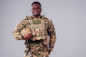 African american soldier with folded arms standing in white studio