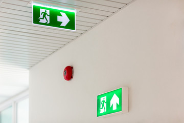 Green emergency exit sign showing the way to escape.Fire exit in the building.