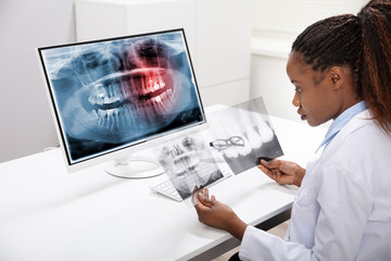 Dentist Examining Teeth X-ray On Computer