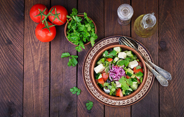 Vegetarian salad with cherry tomato, brie cheese, cucumber, cilantro and red onion. American cuisine. Top view. Flat lay