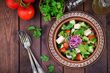 Vegetarian salad with cherry tomato, brie cheese, cucumber, cilantro and red onion. American cuisine. Top view. Flat lay