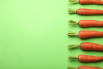 Flat lay composition with fresh carrots on color background. Space for text