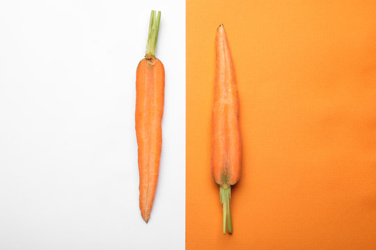 Flat lay composition with halves of fresh carrot on color background © New Africa