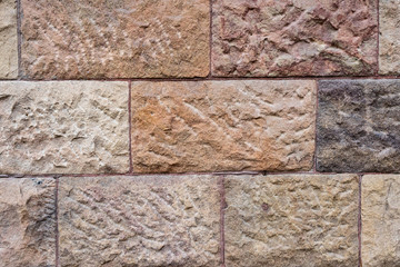 Stone wall texture: brown, orange, terracotta. Stone blocks seamless background. 