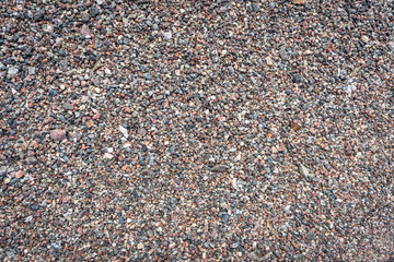 Sea pebble texture. Small multicolored pebble-stones. Close up beach stones surface.