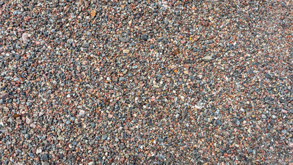 Sea pebble texture. Small multicolored pebble-stones. Close up beach stones surface.