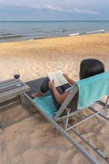 Asian woman reading book in summer vacation