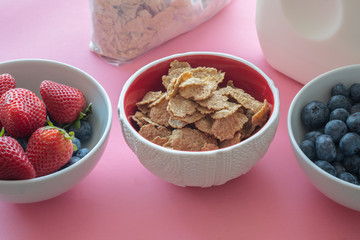 Toasted Oatmeal Flakes with Milk and Fresh Berries, Close up, in Pink Background.  Good Source of Fiber and Vitamins