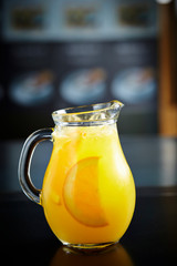 Orange juice in pitcher on black background