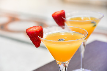 two glasses of Bellini cocktail with prosecco, strawberry decor, Italian bar, traditional aperitif in Milan, aperitif in Florence,