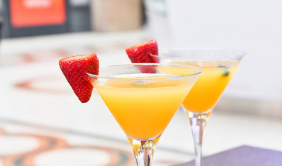 two glasses of Bellini cocktail with prosecco, strawberry decor, Italian bar, traditional aperitif in Milan, aperitif in Florence,