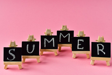 pink summer background.   black cards with letters summer, mint leaves and a cherry. the concept of the season change.