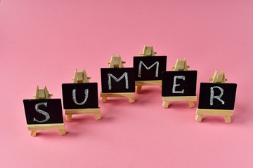 pink summer background.   black cards with letters summer, mint leaves and a cherry. the concept of the season change.