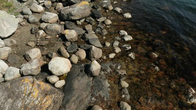 Cinematic Tilt Up Aerial of Scandinavian Nordic Sea Fjord Coast With Sailing and Very Fast Speed Boat Passing By Bay of City in The Background 4k
