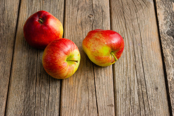three apples on old wooden background