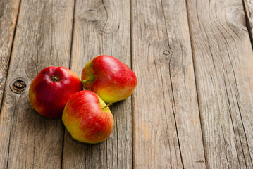 three apples on old wooden background