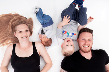 Glückliche Familie liegt am Boden und hat Spaß 